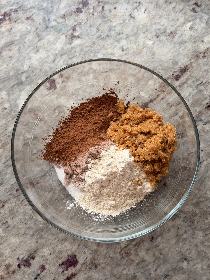 Glass bowl with cocoa powder, brown sugar, and flour on a marble surface – photo 3