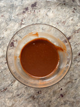 Clear glass bowl with brown liquid on a speckled countertop – thumbnail 6