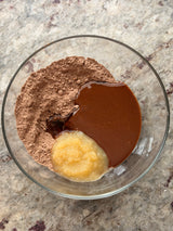 Glass bowl with cocoa powder, melted chocolate, and a dollop of butter on a marble surface – thumbnail 7