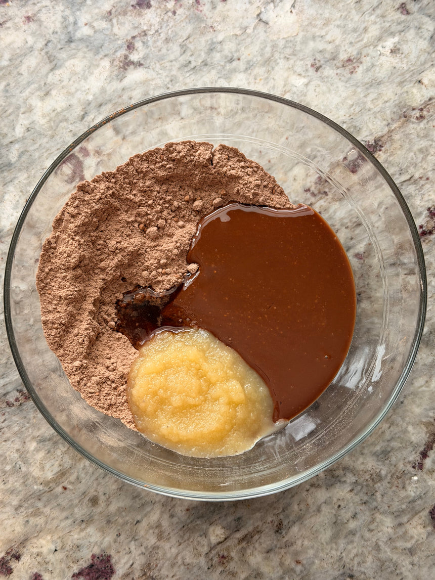 Glass bowl with cocoa powder, melted chocolate, and a dollop of butter on a marble surface – photo 7