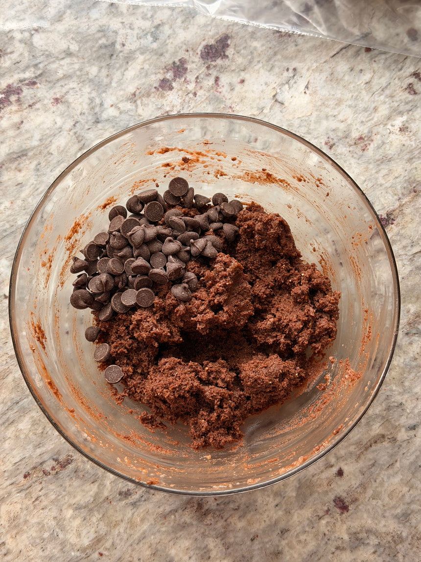 Glass bowl with chocolate cookie dough and chocolate chips on a marble countertop – photo 9