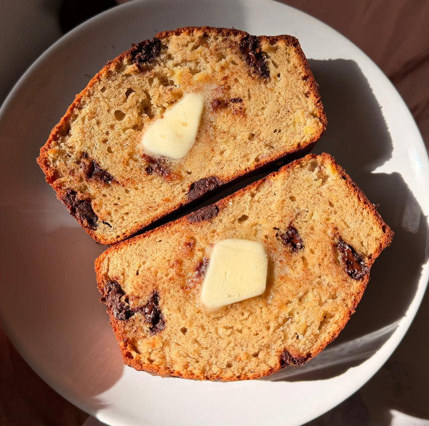 Two slices of banana bread with butter on a white plate – photo 1