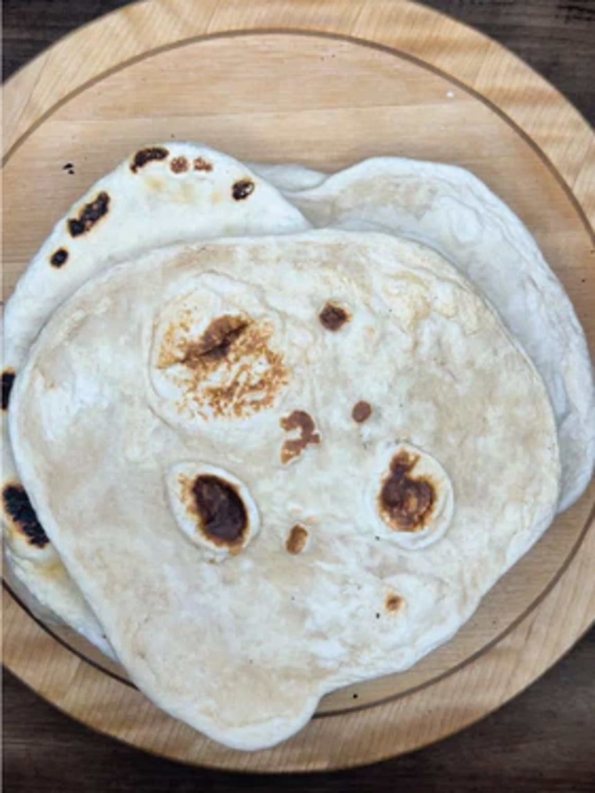 Three high protein greek yogurt tortillas on a wooden plate with charred spots – photo 1